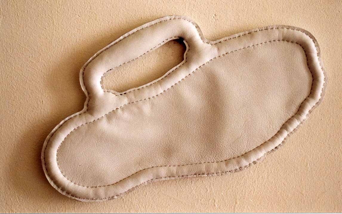 Forme de trace de pas en cuir avec une poignée de valise.