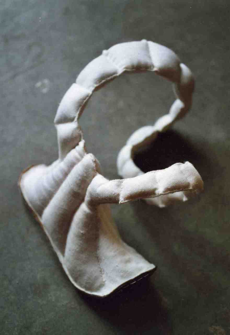 Objet, comme un collier en coussinets de textile se terminant en chaussure.