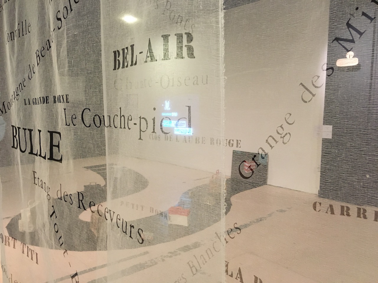 Vue d'exposition, à travers les textiles transparents