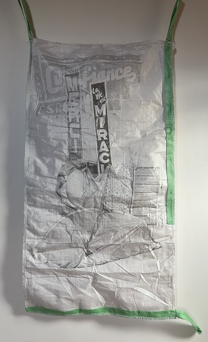 Dessin au graphite sur 2 sacs à gravats blancs d'un abri de fortune dans le métro