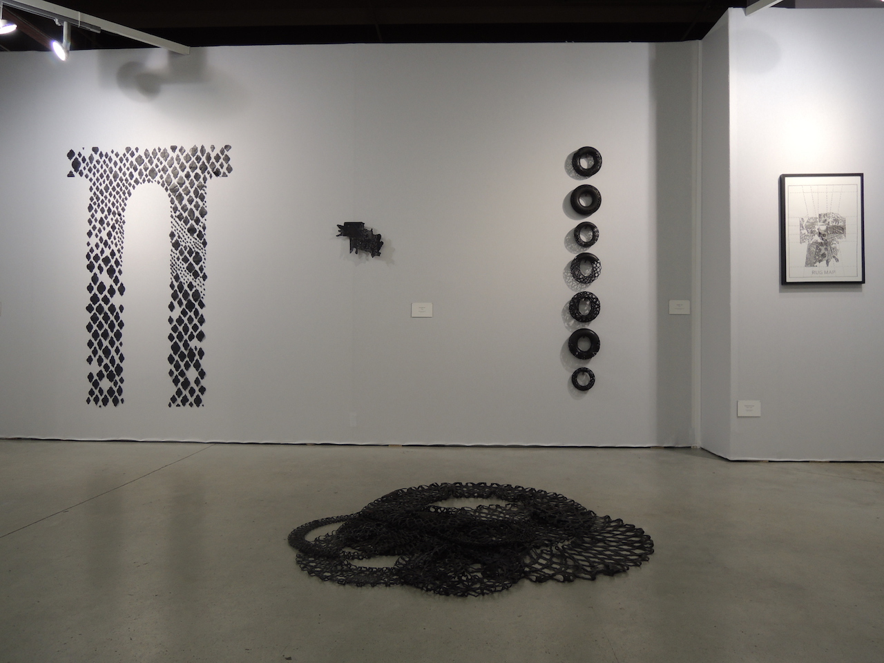 Vue d'ensemble de l'installation avec une sélections de travaux en noir et blanc, en chambre à air et en dessin à l'encre de Chine