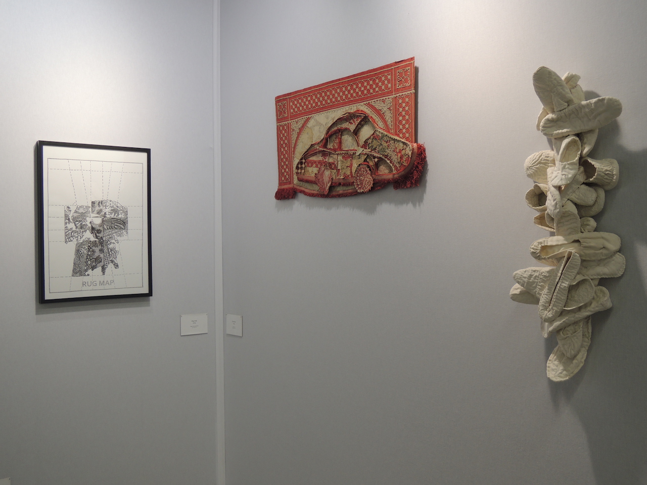 Vue d'un dessin et de deux pièces textile au mur