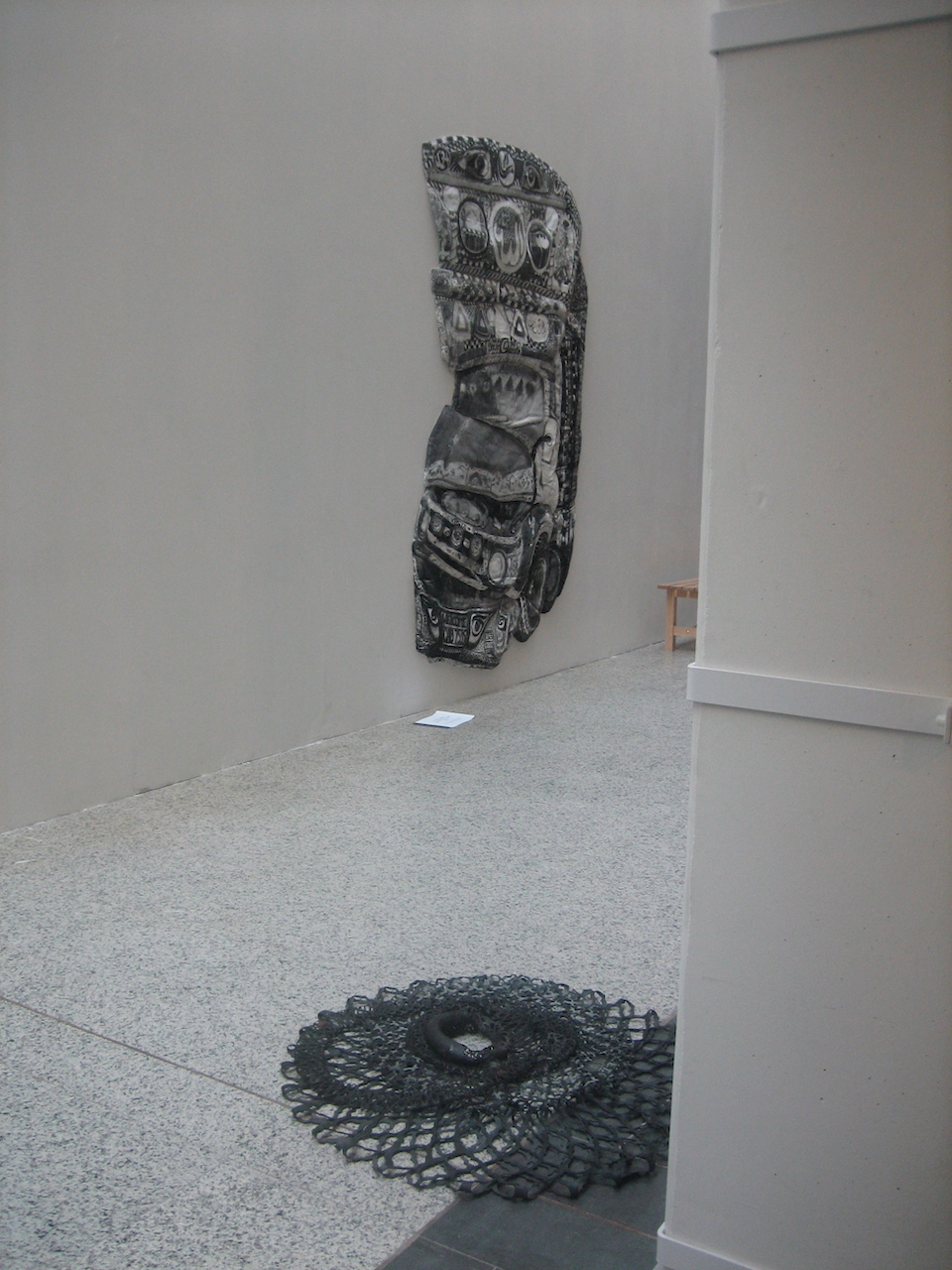 Installation au sol de chambres à air dentellées avec un camion en textile peint à l'encre de Chine de Merina Beekman accroché au mur au fond