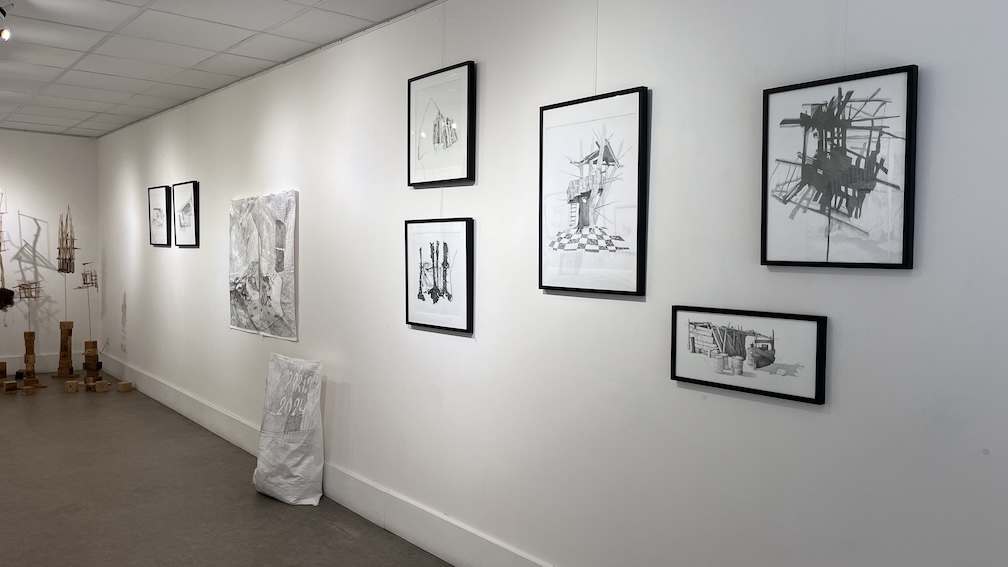 Vue d'ensemble, dessins d'abris de fortune encadrés, accrochés au mur