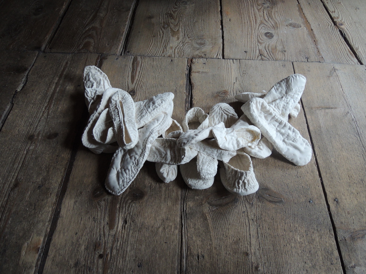 Collection de chaussons blancs en tissu attachés ensemble sur une ligne